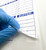 Lab technician peeling back a Buffer Material Label in biotech laboratory