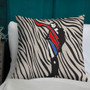 Napoleon zebra pillow with red sash and blue accent silhouette on white chair against teal wall.