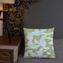 Sage and light blue abstract camo Botticelli Girls pillow on gray quilted bed with studded headboard.