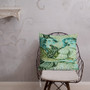 Forest green and turquoise Botticelli Girls portrait pillow on wire chair with scroll wall detail.
