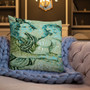 Mint and cyan Botticelli Girls portrait pillow on beige sofa with periwinkle chunky knit blanket.