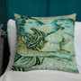 Turquoise and cream Botticelli Girls two-figure pillow on white bedding against dark teal paneling.