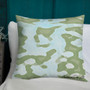 Olive and light blue watercolor camo Botticelli Girls pillow on bed against dark teal wall.