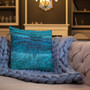 Deep blue textured Da Vinci Blue Bird pillow nestled in light blue chunky knit on tufted sofa.