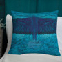 Dark blue spread wings on turquoise Da Vinci Blue Bird pillow against white pillows and teal wall.