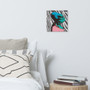 Square Da Vinci zebra caricature canvas above grey and striped pillows on bed beside wood nightstand.