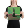 Hands holding square Goya Black Duchess canvas—black dress against lime and pink dotted landscape.