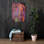 Botticelli Venus Orange Purple canvas on dark wood-slat wall above wicker chest and rubber plant.