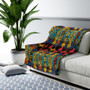 Klimt Beethoven Portrait sherpa blanket draped on white sofa beside bird-of-paradise plant.