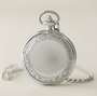 Closed Botticelli Venus silver pocket watch: ornate floral cover medallion with matching curb chain.