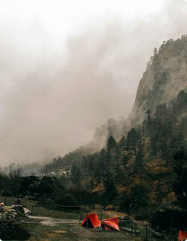 2 orange tents next to a mountain