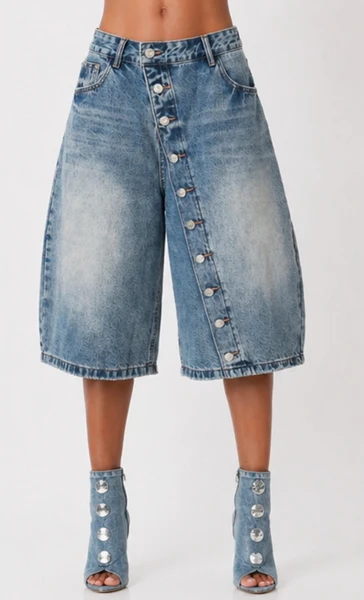 Front view of women’s long denim jorts with button-up detail, wide-leg culotte silhouette, and light blue faded wash.