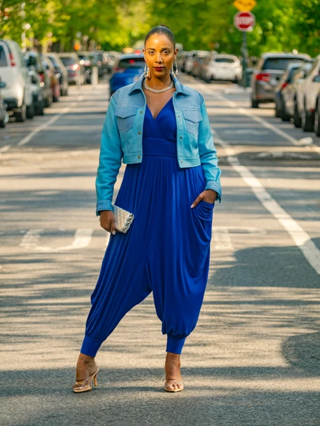model on the streets of Brooklyn wearing a harem style royal blue jumpsuit and baby blue jacket