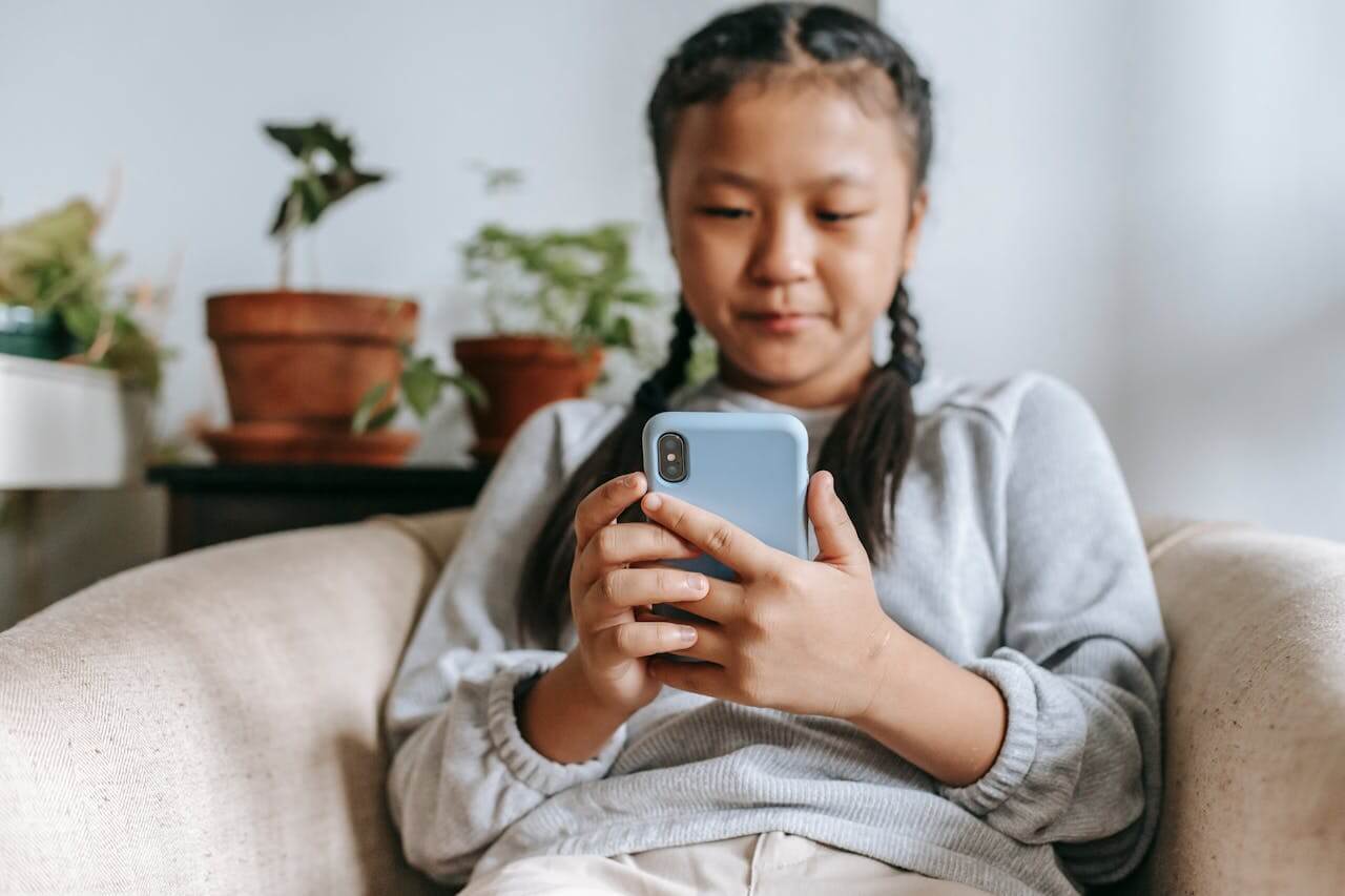 girl sitting on chair with her smartphone
