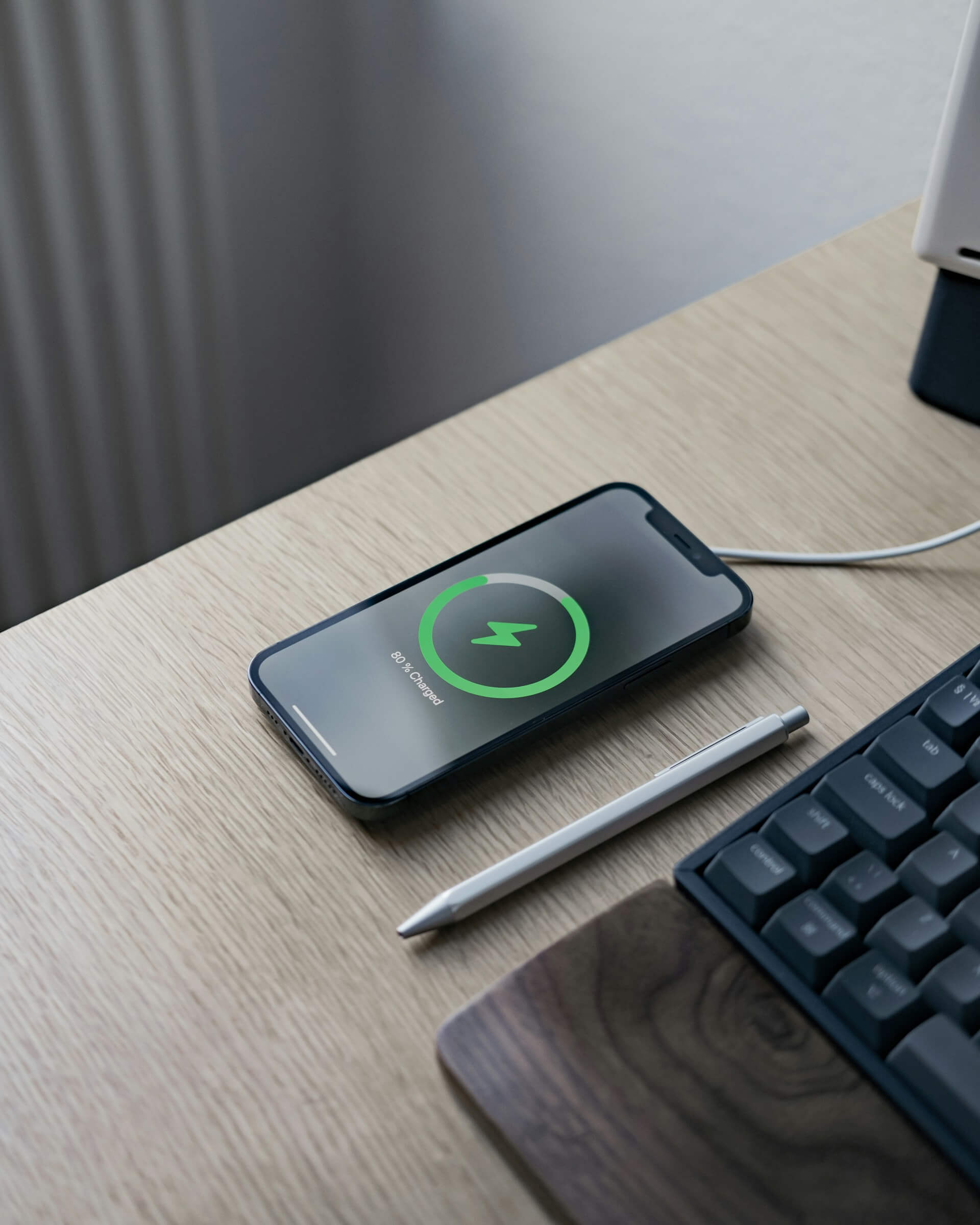 an iPhone charging wirelessly on a desk