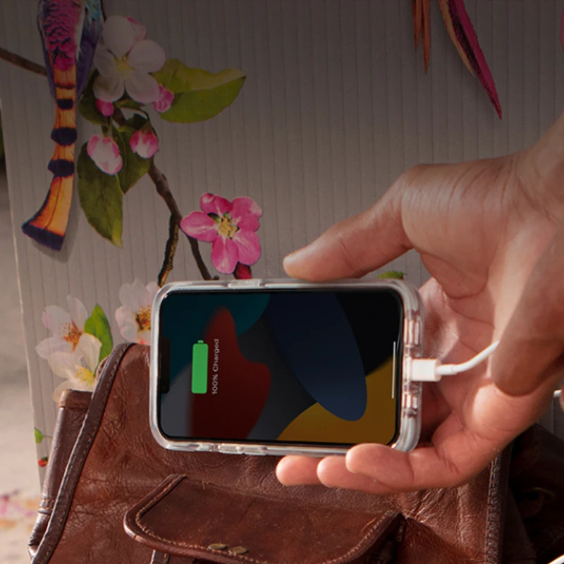 Person holding up an iPhone while it’s being charged by a wire