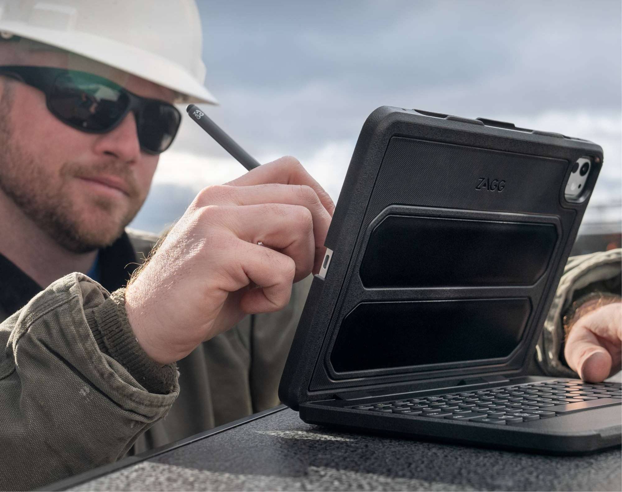 man using a stylus on an iPad in a rugged book keyboard case