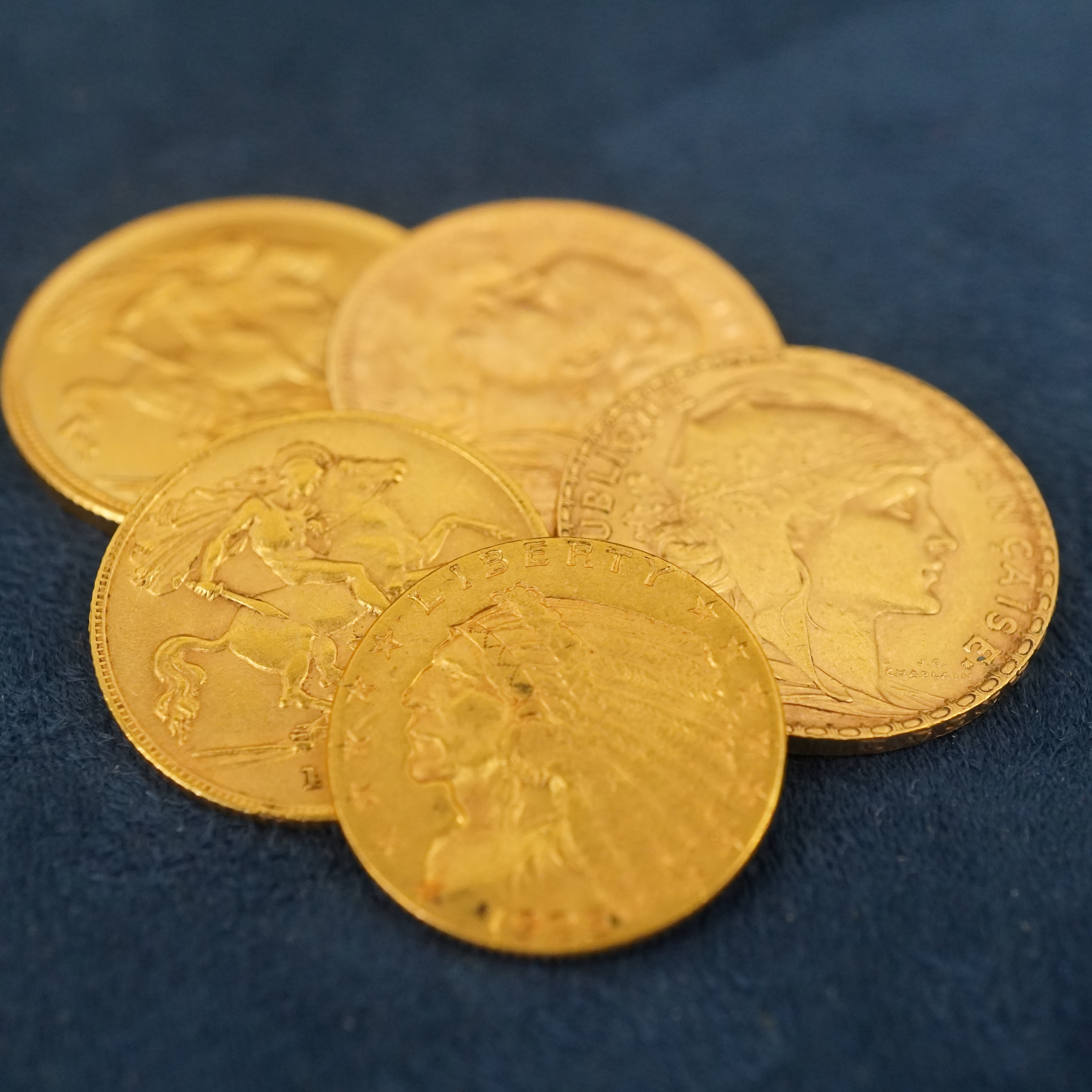 A small pile of various gold coins.