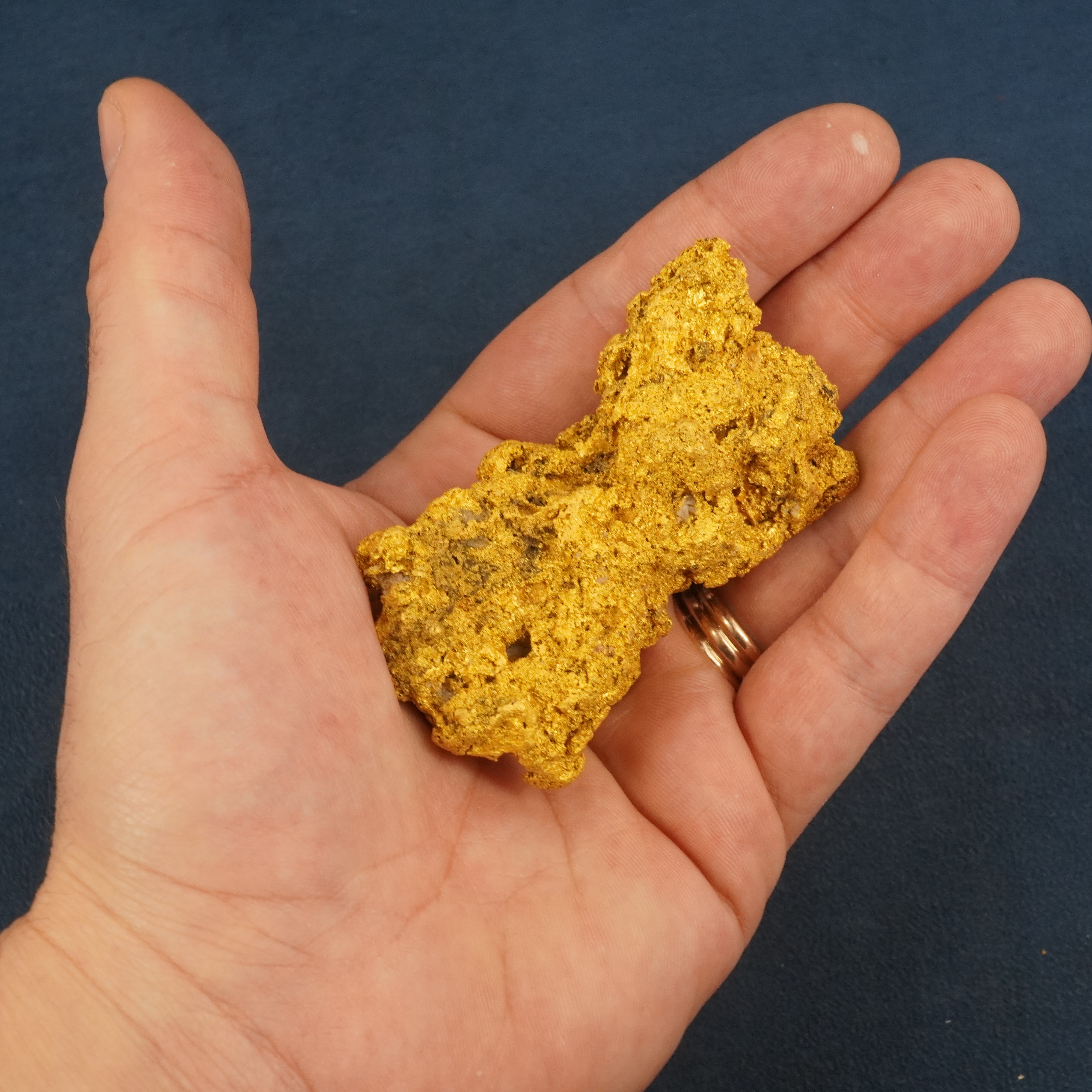 243 gram 23 karat Australian gold nugget held in palm of hand for size reference
