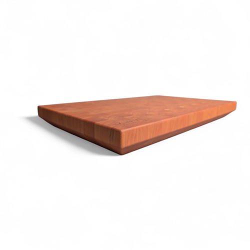 Angled view of a modern American Cherry end-grain cutting board featuring a 45-degree chamfered bottom edge that creates a floating effect. Made in Edinburgh.