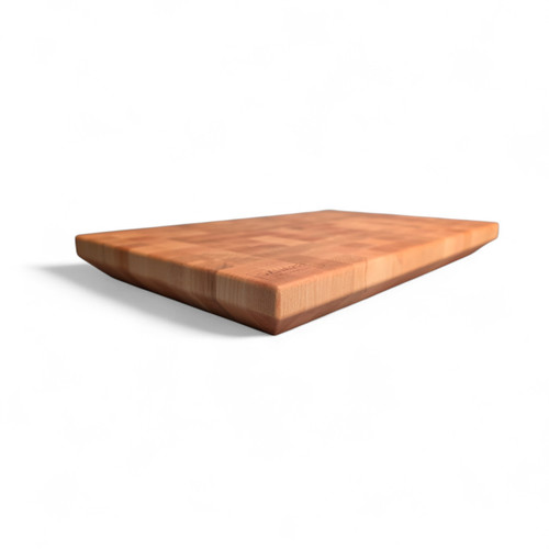 Angled view of a modern American Maple end-grain cutting board featuring a 45-degree chamfered bottom edge that creates a floating effect. Handmade in Edinburgh.