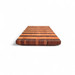 alt="Side profile view of the striped walnut and maple chopping board showing the deep 2.5cm undercut chamfer that serves as a continuous handle around the board."