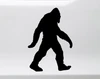 Walking Bigfoot Sasquatch silhouette vinyl decal featuring a shaggy cryptid with long arms and large feet on a vehicle window