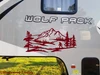 Bigfoot Sasquatch mountain landscape vinyl decal V2 featuring walking cryptid silhouette, mountain peaks, evergreen forest and pine trees for RV campers and travel trailers