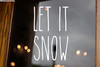 Let It Snow Christmas vinyl decal featuring tall skinny farmhouse style handwritten lettering arranged in two lines on glass window