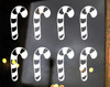 Set of eight striped candy cane Christmas vinyl decals arranged in two rows of four on a glass window, featuring traditional curved hooks and peppermint stripe cutouts