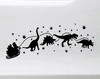 Christmas vinyl window decal featuring Santa Claus in a sleigh pulled by Brachiosaurus, Stegosaurus, T-Rex and Triceratops dinosaurs surrounded by stars and dinosaur footprints