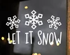 Let It Snow winter vinyl window decal featuring three decorative snowflakes above playful hand-lettered holiday typography