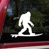 Bigfoot surfing vinyl sticker decal showing a playful Sasquatch riding a surfboard in a beach themed silhouette design
