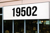 Large storefront address numbers vinyl decal in Bebas Neue font with modern minimalist business signage style