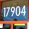 Large storefront address numbers vinyl decal in Futura Bold font with modern minimalist business signage style