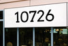 Arvo font storefront address numbers vinyl sticker decal applied to business window with clean slab serif lettering