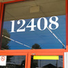 Chronicle Display Bold storefront address numbers vinyl sticker decal applied to business window with elegant serif lettering