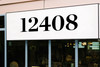 Chronicle Display Bold storefront address numbers vinyl sticker decal applied to business window with elegant serif lettering