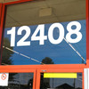 Sohne Bold storefront address numbers vinyl sticker decal applied to business window with clean modern sans serif lettering