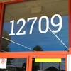 large Roboto Slab vinyl storefront numbers applied to modern business window with geometric serif typography