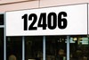 large Anton font vinyl storefront numbers applied to modern business window with bold condensed geometric typography