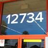 large Proxima Nova vinyl storefront numbers applied to modern business window with geometric minimalist typography