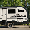 Mount Hood vinyl decal featuring the Oregon mountain above an evergreen pine forest displayed on the rear of an RV camper