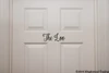 The Loo bathroom door vinyl decal featuring elegant Nouradilla cursive script lettering, available in seven sizes from 5.5 x 2 inches to 27 x 10 inches for restroom doors, powder rooms and bathroom decor
