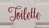 Toilette bathroom door vinyl decal featuring elegant Nouradilla script lettering with decorative flourishes, available in eight sizes from a 2-pack of 4.5 x 2 inch decals to a single 22.5 x 10 inch decal for powder rooms and restroom doors