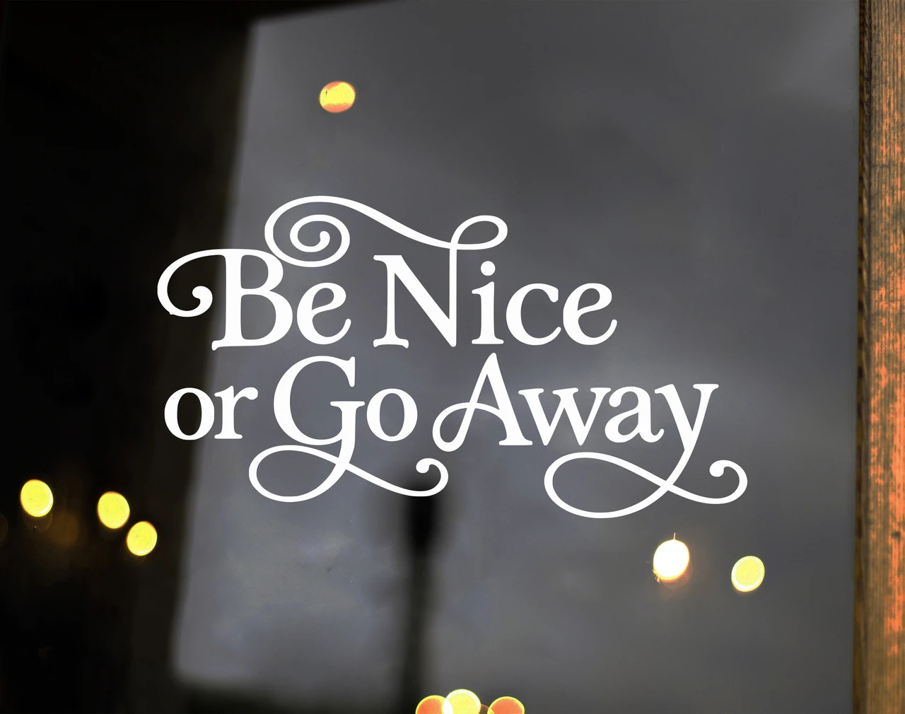 Be Nice or Go Away vinyl decal in decorative Albemarle Swash font with flourished lettering