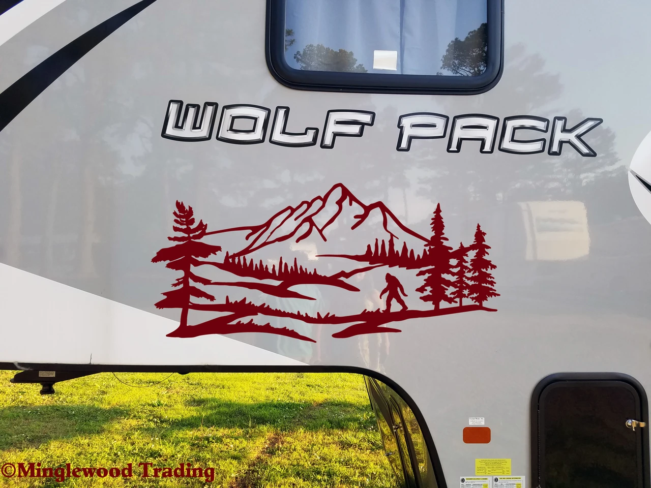 Bigfoot Sasquatch mountain landscape vinyl decal V2 featuring walking cryptid silhouette, mountain peaks, evergreen forest and pine trees for RV campers and travel trailers