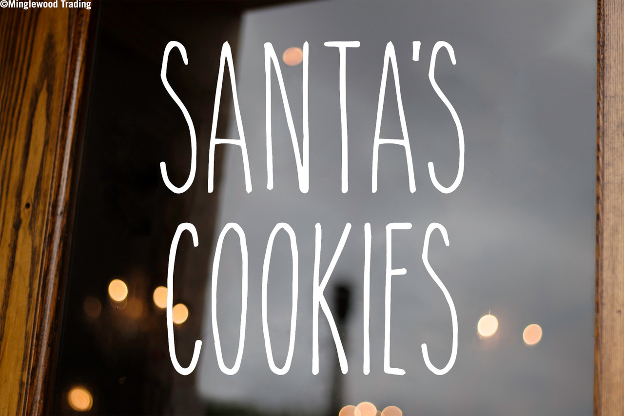Santa's Cookies Christmas vinyl decal with tall skinny farmhouse style handwritten lettering arranged in two lines on glass window