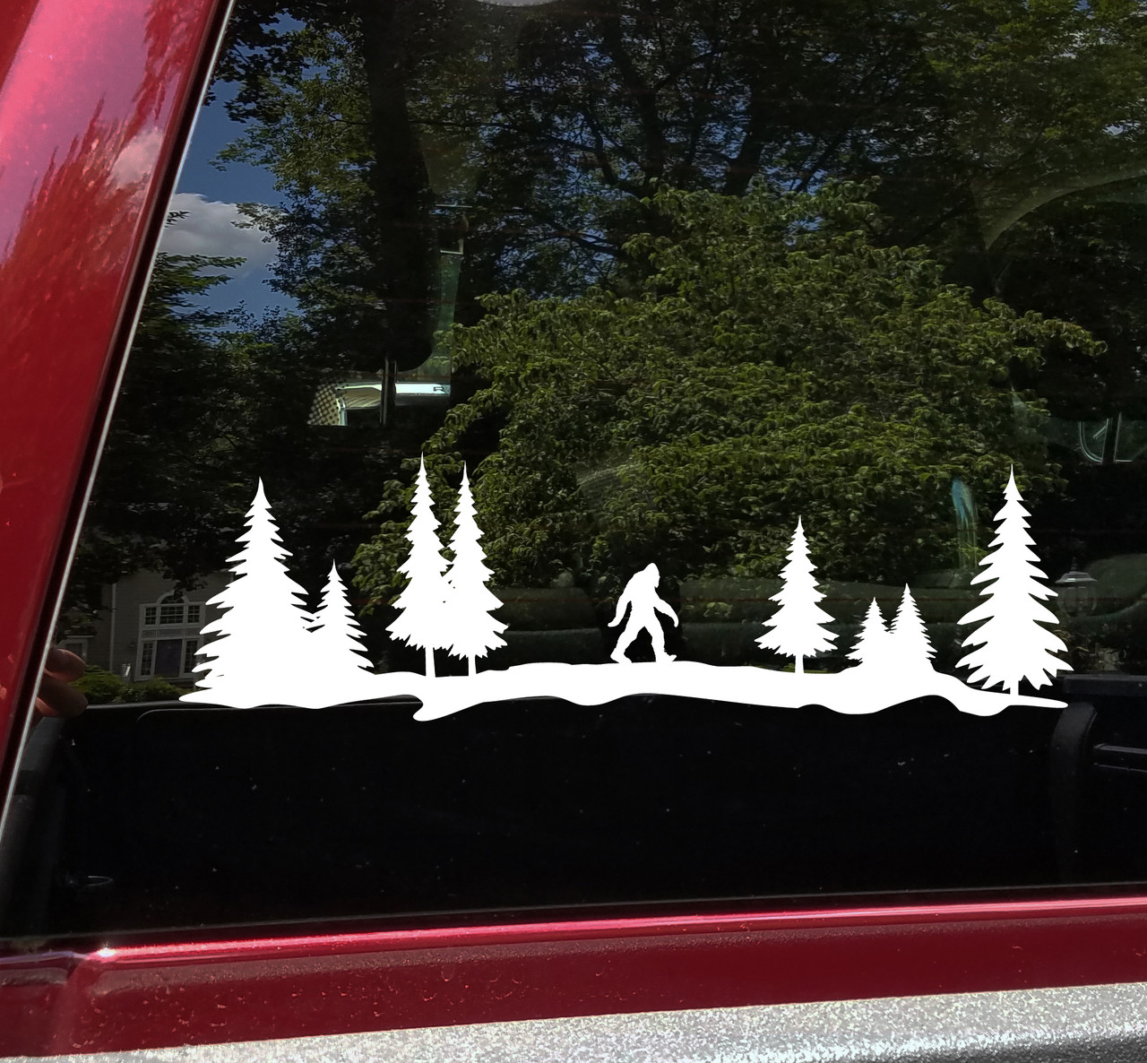 Bigfoot Sasquatch walking through a forest of tall evergreen pine trees in a wide horizontal tree line silhouette vinyl decal for RV camper and travel trailer