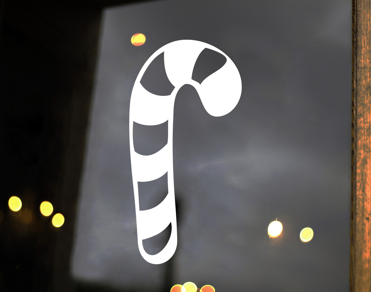 Striped candy cane Christmas vinyl decal displayed on a glass window featuring a curved hook and diagonal candy stripe cutouts